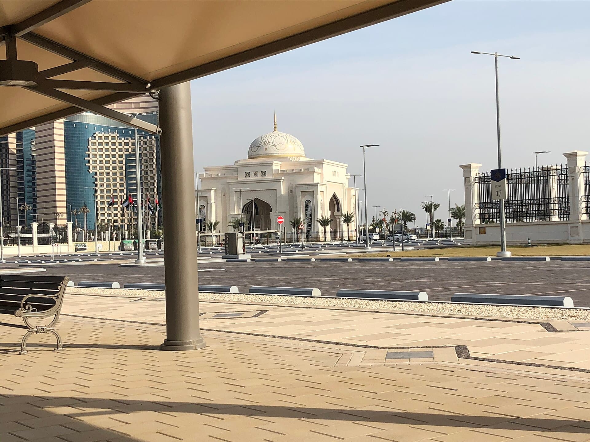 Qasr Al Watan's golden-domed ceremonial gate seen across the palace grounds, Abu Dhabi's skyline behind