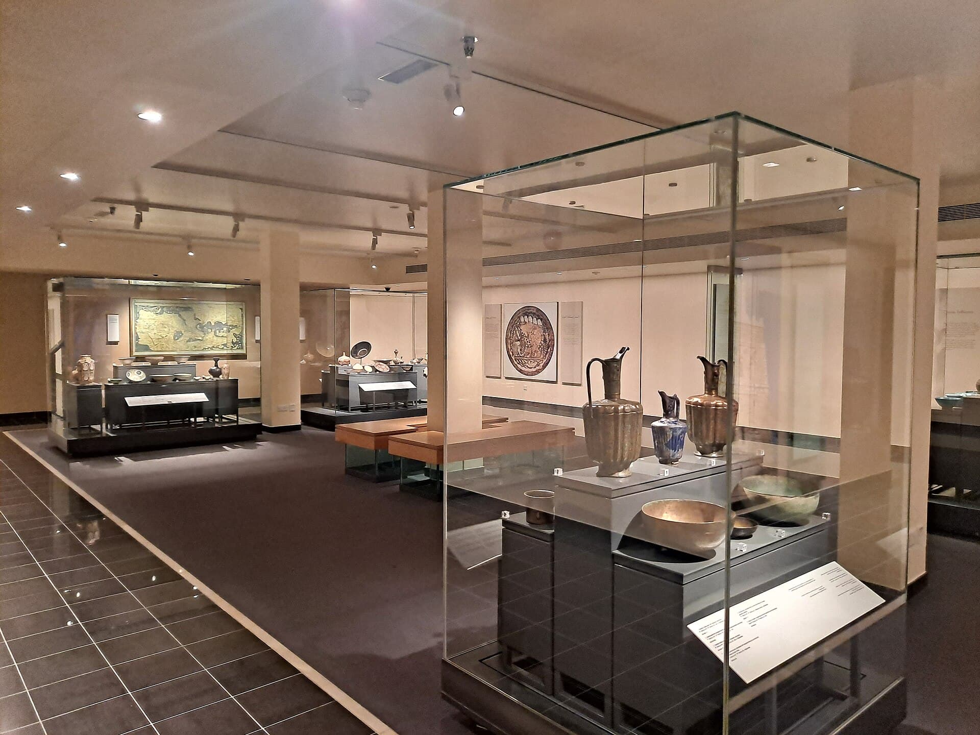 A gallery inside the Sharjah Museum of Islamic Civilization, glass cases displaying ceramics and metalwork