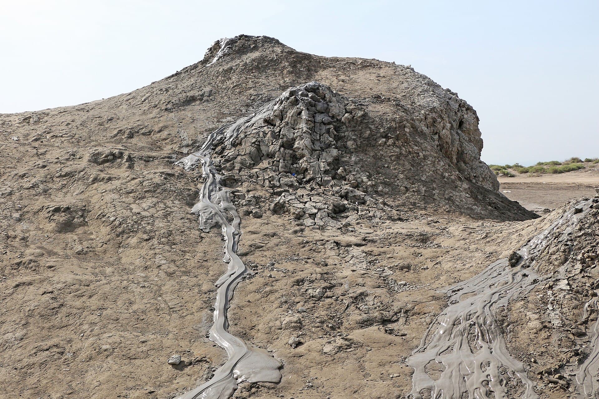 Grey mud cones near Gobustan with wet mud trickling down their slopes in channels